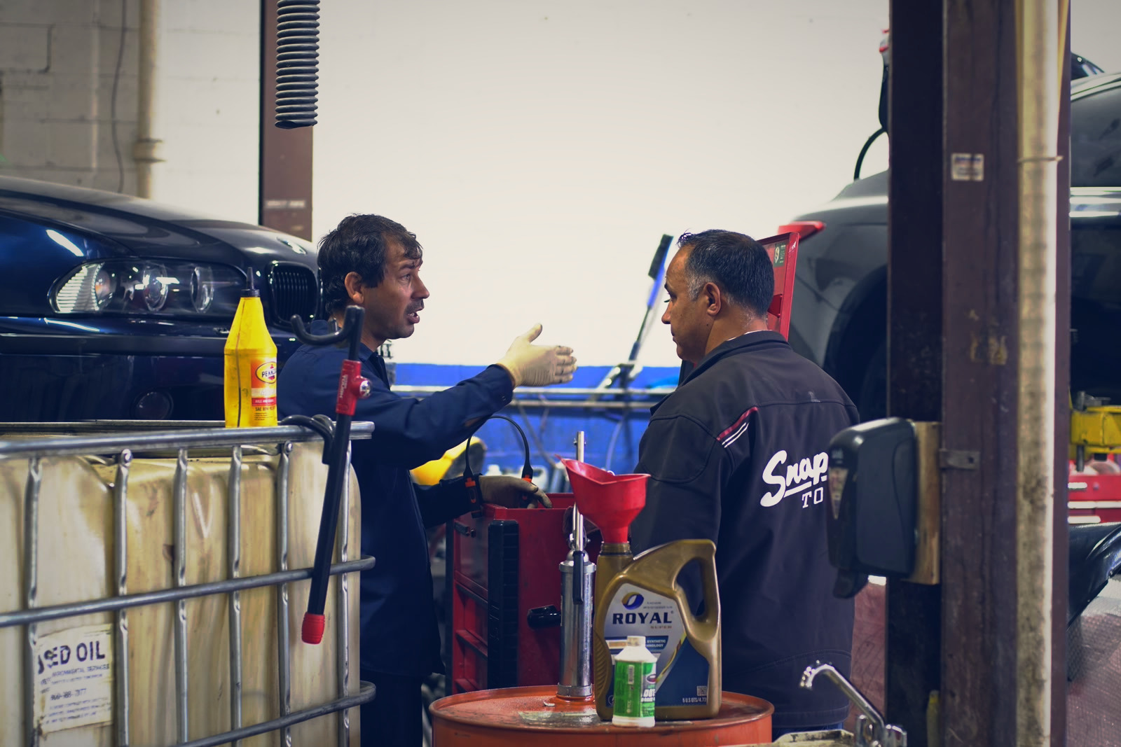 Two Alexandria Car Clinic technicians talking in the shop
