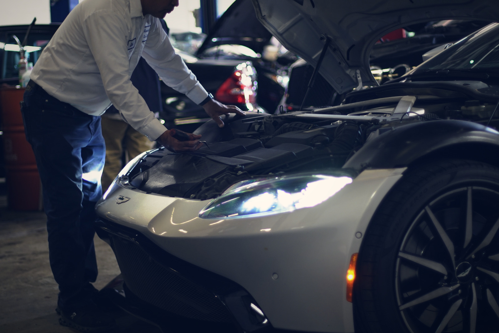 A technician working on the underside of a car